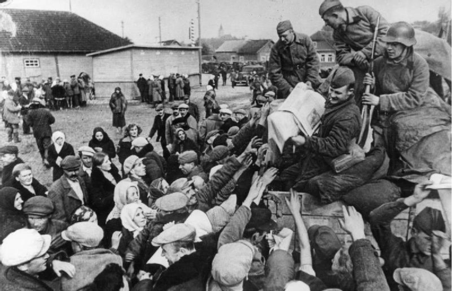 Red Army troops distributing Soviet propaganda newspapers to villagers outside Vilnius.