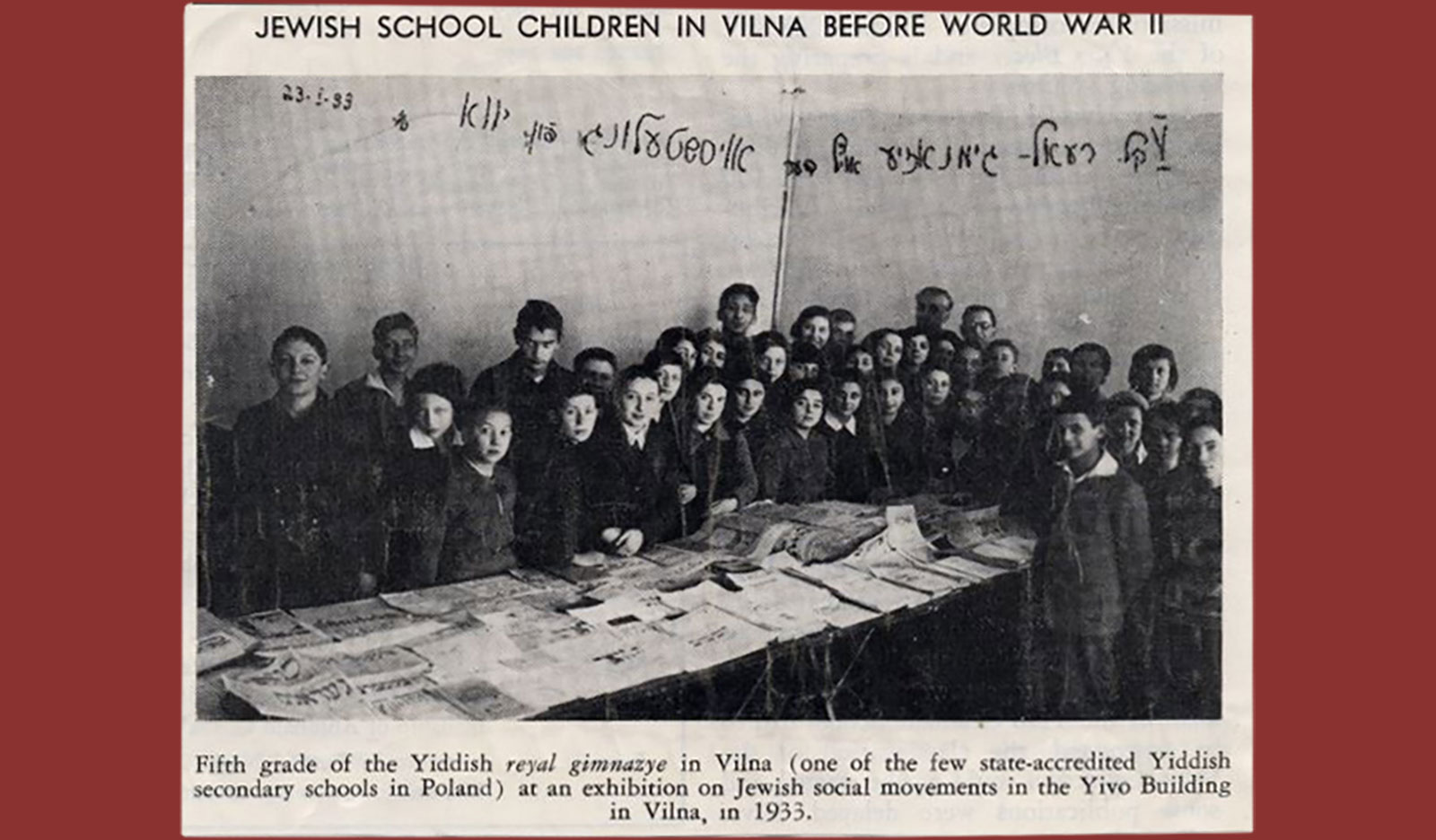 Newspaper clip of 5th grade Real Gymnasium students posing at a YIVO exhibition on Jewish social movements. Vilna, 1933.