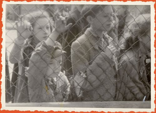 Photograph of children behind a wire fence