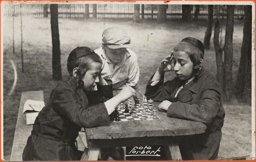 Three boys playing a game of chess