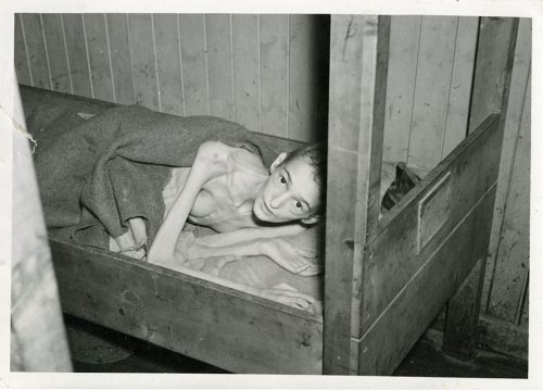 Photograph of a liberated young man in a bunk