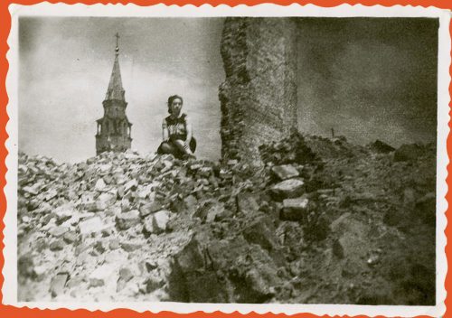 A woman sits in the ruins of the Warsaw Ghetto