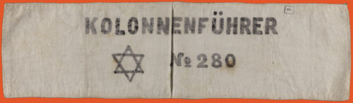 White armband written Kolonnenführer at the top center in black. On the bottom center is a star of david and the number 280, also in black.