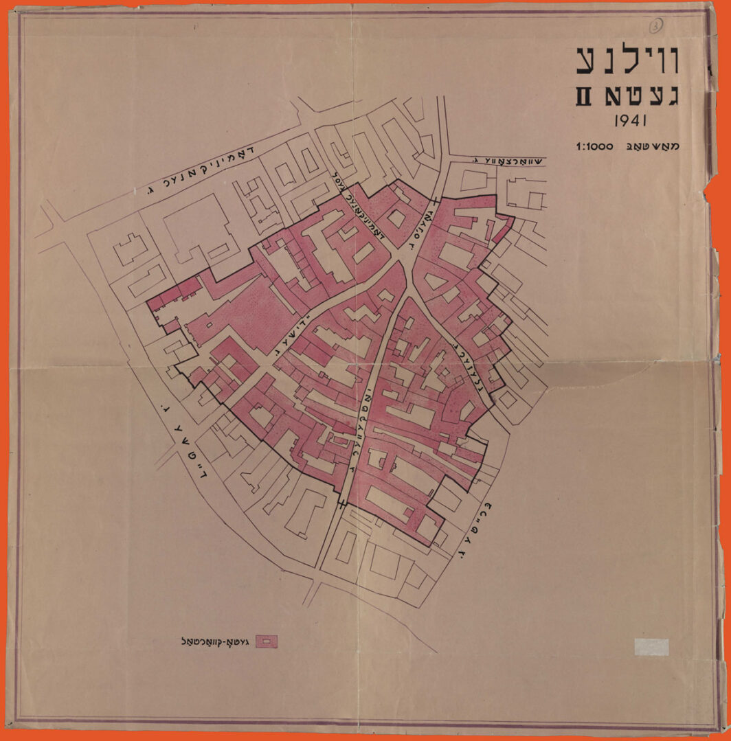 Black ink drawing on tracing paper of city blocks. A section at the center is painted in red, denoting the area of the second ghetto. Street names and map title are in Yiddish.