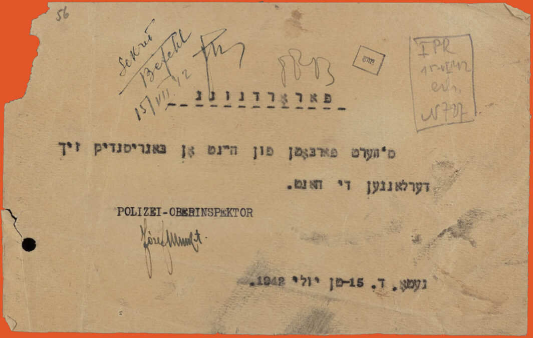 Typed document in Yiddish. Black ink on white paper. Signature in green ink on the bottom. Rectangular shape, landscape orientation. Torn on upper left side.